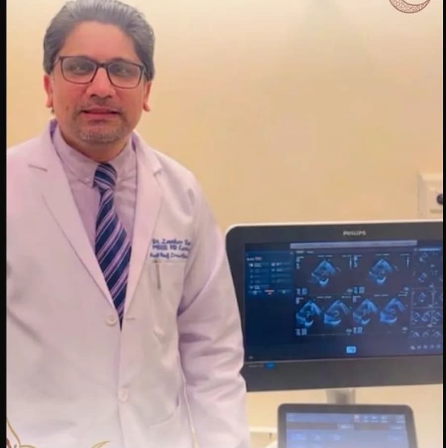 Dr. Zeeshan Shoukat beside a Philips echocardiography machine